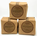 Three small brown paper bags (sealed and filled with salt) are stacked upon one another against a plain white background. The labels read JQ Dickinson Salt Works Heirloom Finishing Salt.